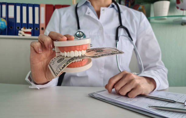 a dentist holding a dental model with a bill 