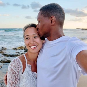 Happy couple in love kissing taking selfie together on smartphone on beach. Vacation tourist trip to seaside resort, summer vacation, multicultural family Asian African American, happiness, date, love